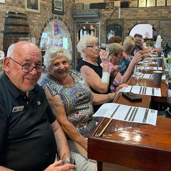 A group of older individuals enjoying drinks at a bar.