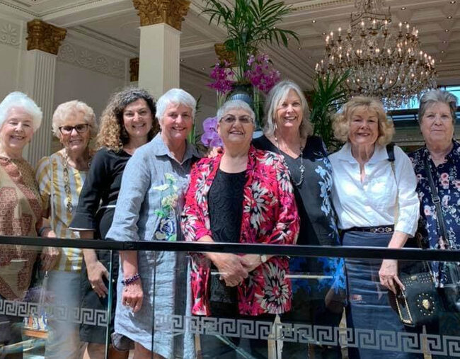 A group of women standing in front of a chandelier during a tour package in Australia.