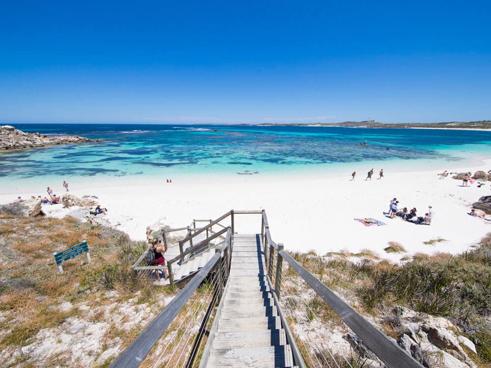 A beach with stairs leading to a white sandy beach is a popular spot for tourists visiting Queensland.